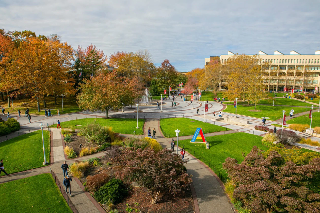Stony Brook's campus quad in autumn, fountain and academic buildings in view